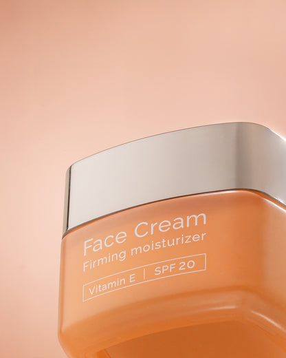 Face cream with SPF20 jar with silver lid on a peach background
