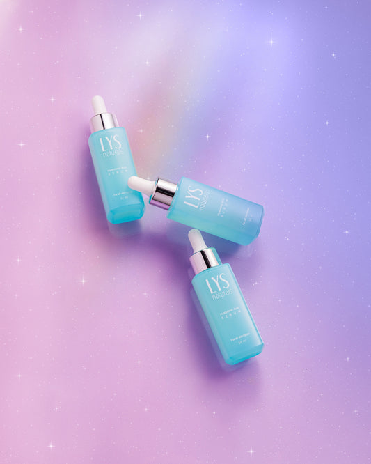 Three blue LYS skincare bottles on a gradient purple background