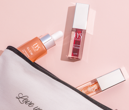 LYS skincare products including a pouch, serum, and lip balm on a pink background