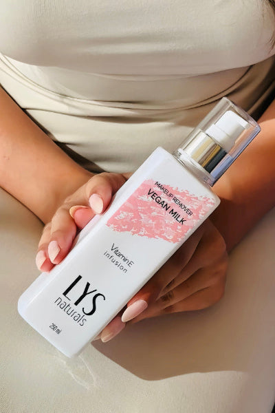 Person holding a bottle of 'LYS Naturals' vegan milk